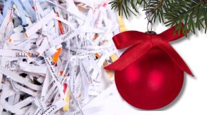 Image of a Christmas tree ornament in front of a pile of shredded paper